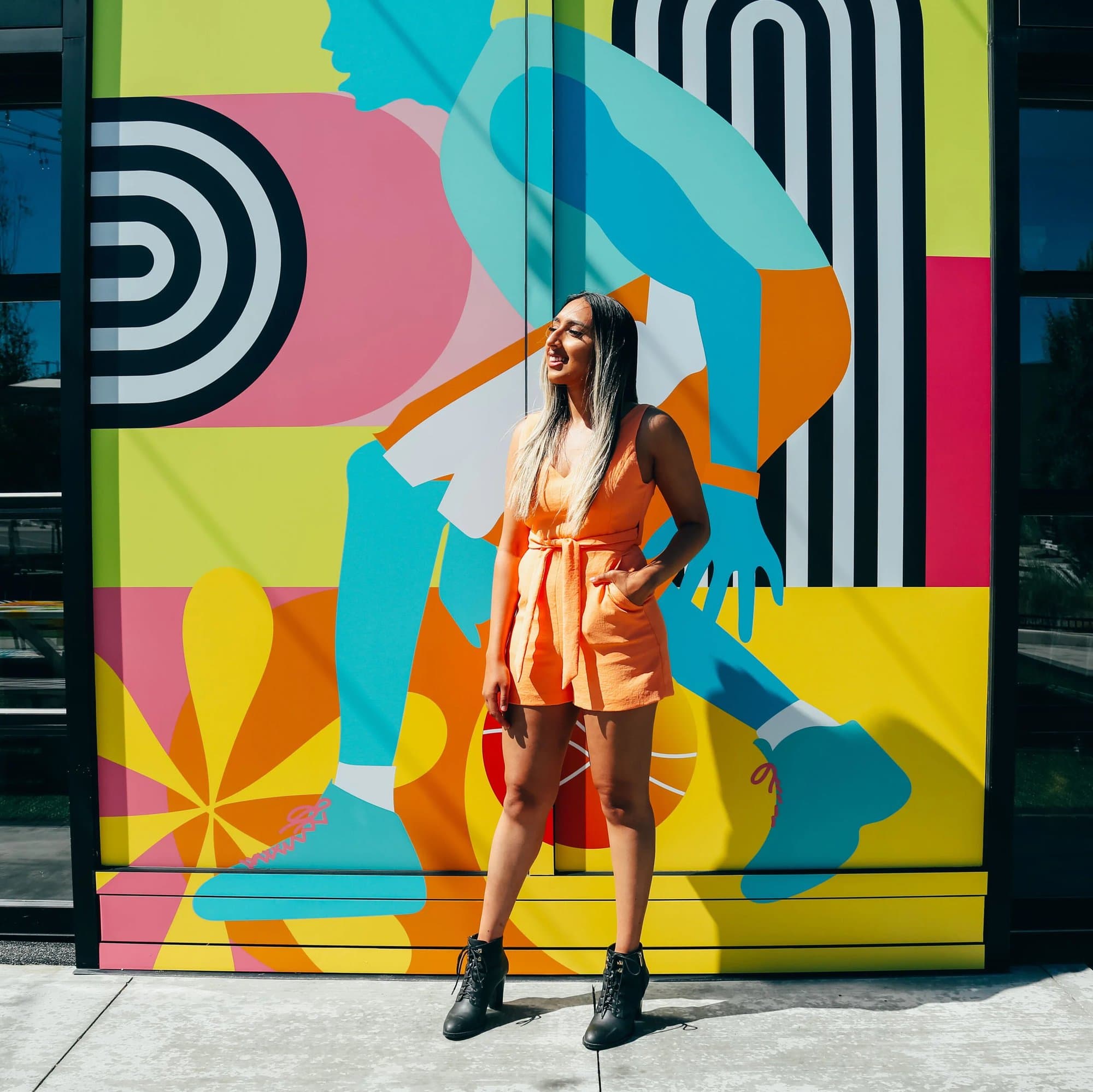 Kiran Rai-Bhullar in front of her window decal design at Deerfoot City for the YYC Block Party