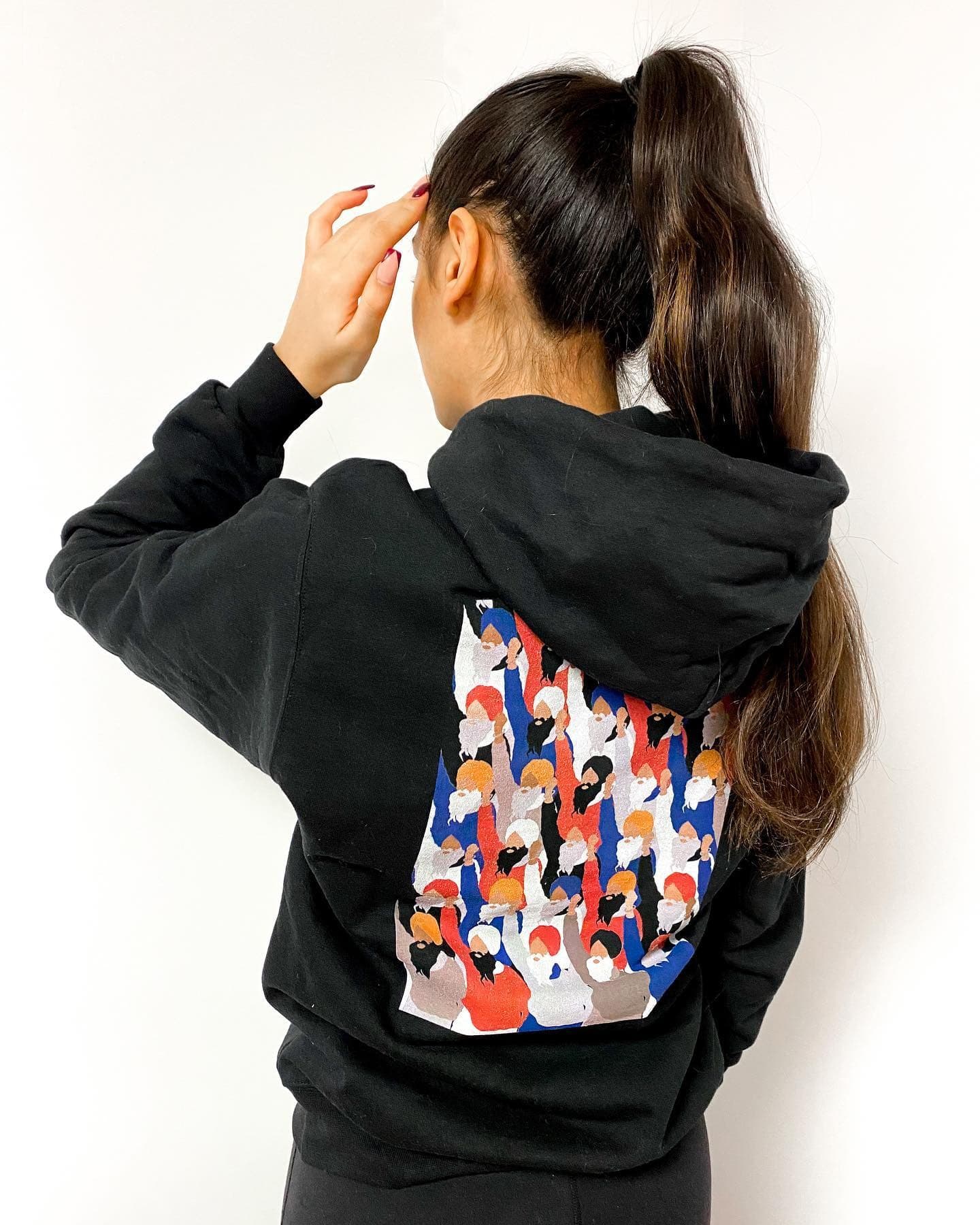 A woman seen from behind in a black hoodie printed with the Long Live Farmers design