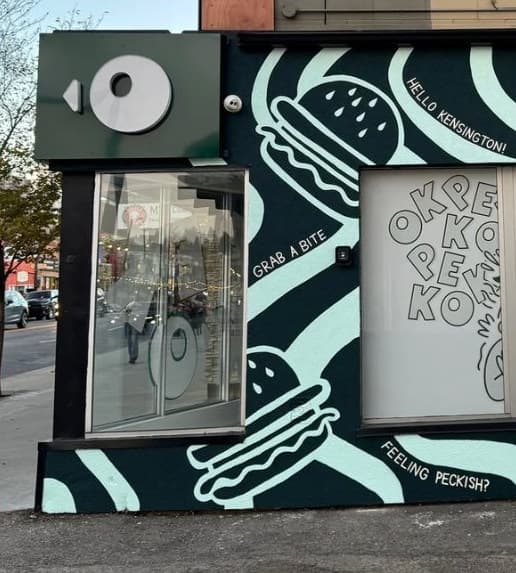 Pekko's entrance: burgers and the lines GRAB A BITE, HELLO KENSINGTON! and FEELING PECKISH? in black and white