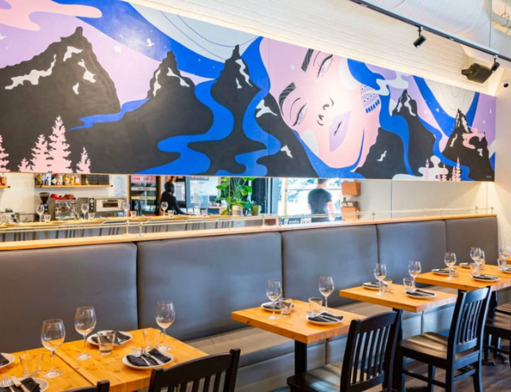 Uprooted seen from the left, above the banquette and set tables at UNA Pizza + Wine in Bridgeland